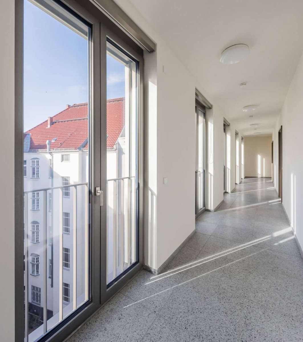Breiter Flur mit Oberlichtern und Zugang zum Balkon