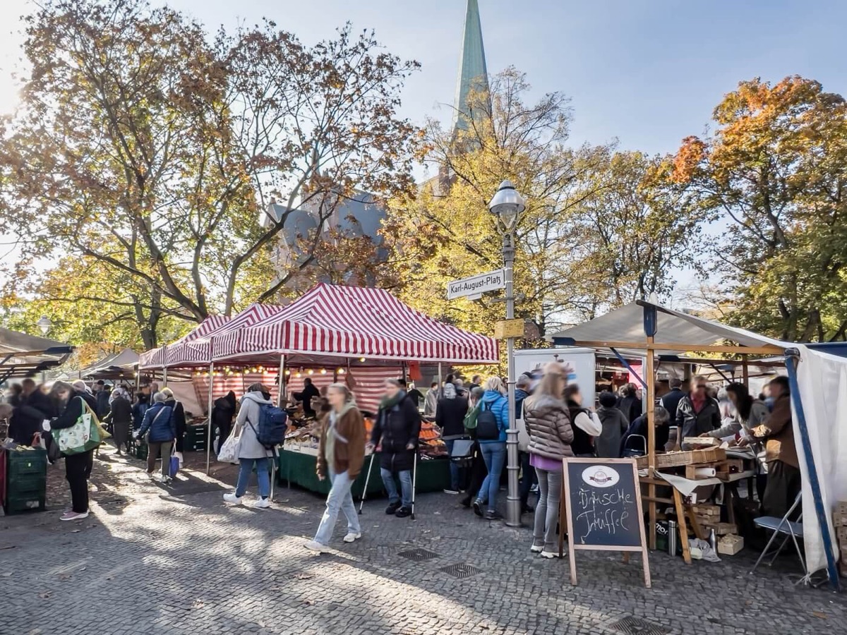 Wochenmarkt im Kiez mit Kirche im Hintergrund